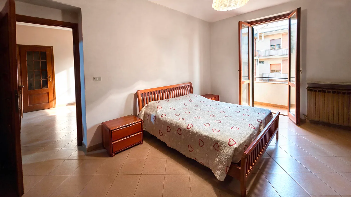 Camera da letto matrimoniale con porta finestra sul balcone, sgombrata e aperta alla luce (dopo)