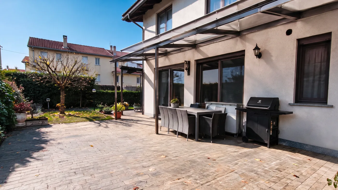 Veranda sul giardino con tavolo, sedie e barbecue, col sole e la pavimentazione asciutta (dopo)