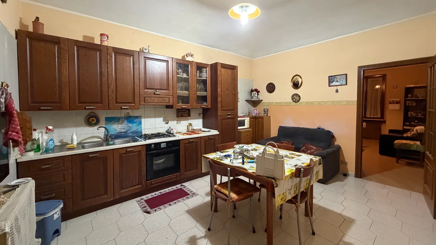 Cucina abitabile con divano e tavolo da pranzo, sgombrata e riordinata (prima)